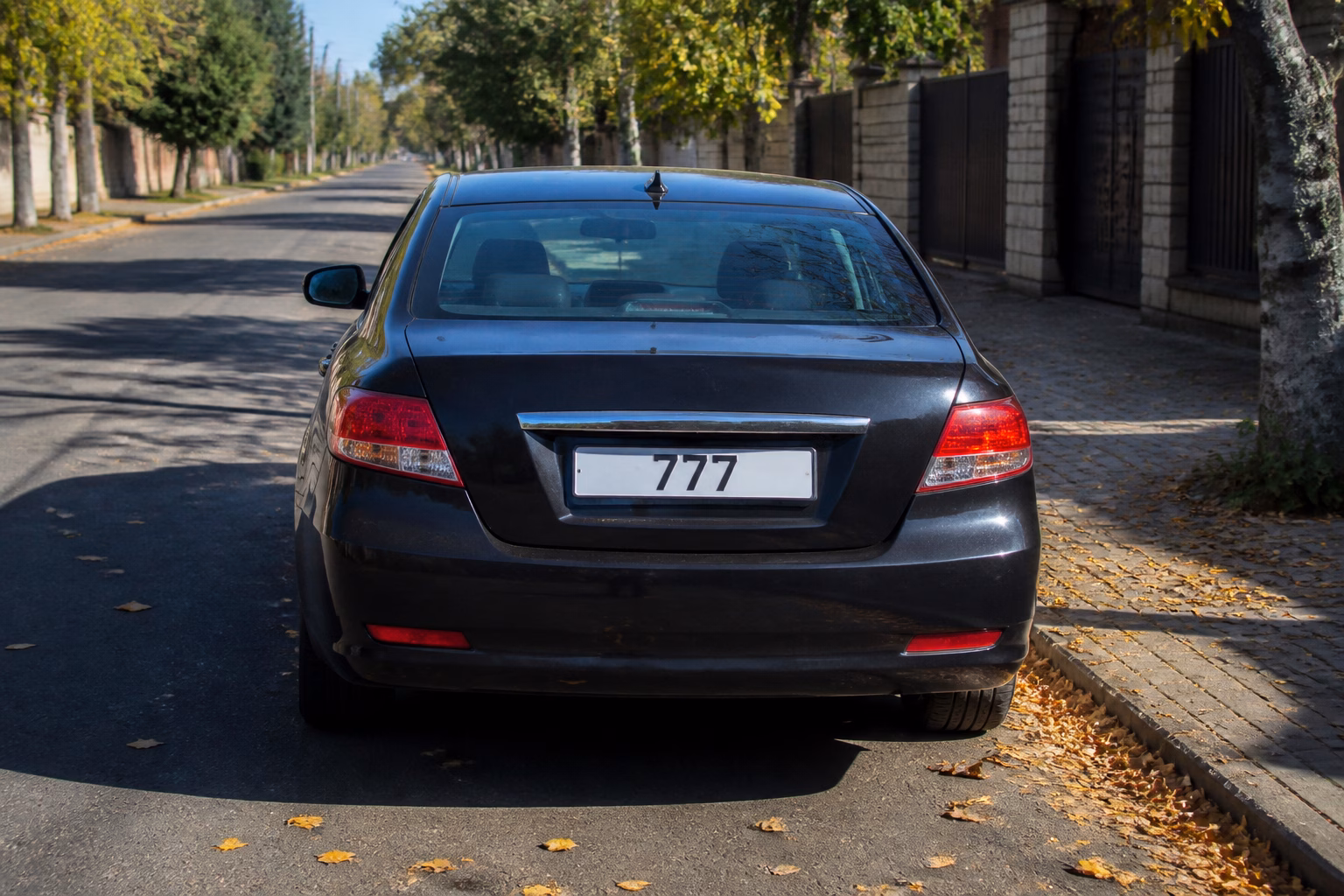 Автомобільний номер з числом 777 на тихій вуличці