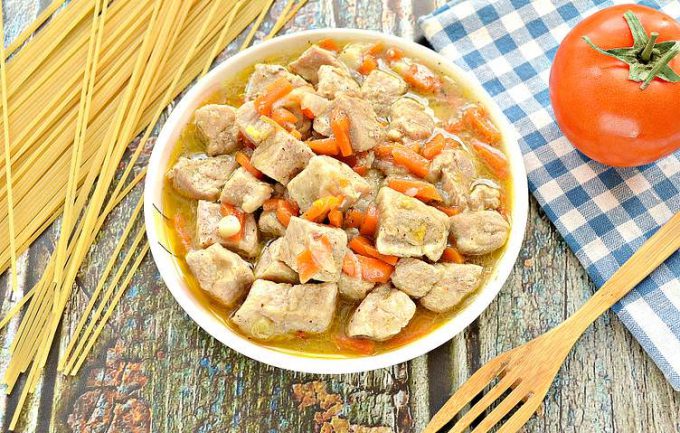 Тушкована свинина з цибулею та морквою на сковороді