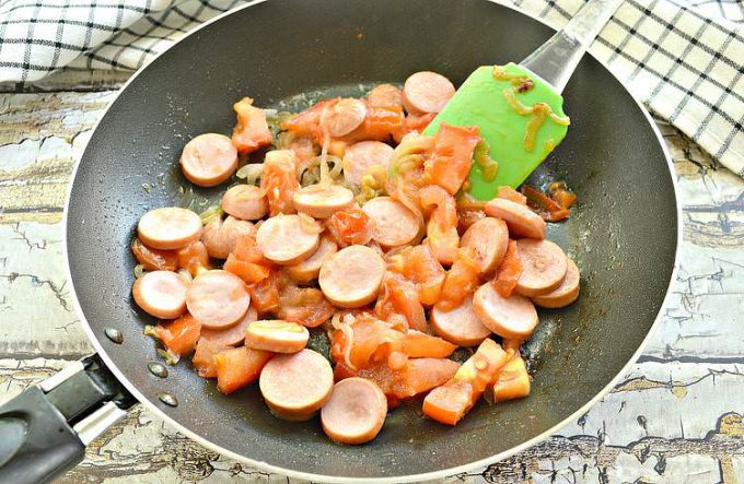 Омлет із сосисками та помідорами на сковороді