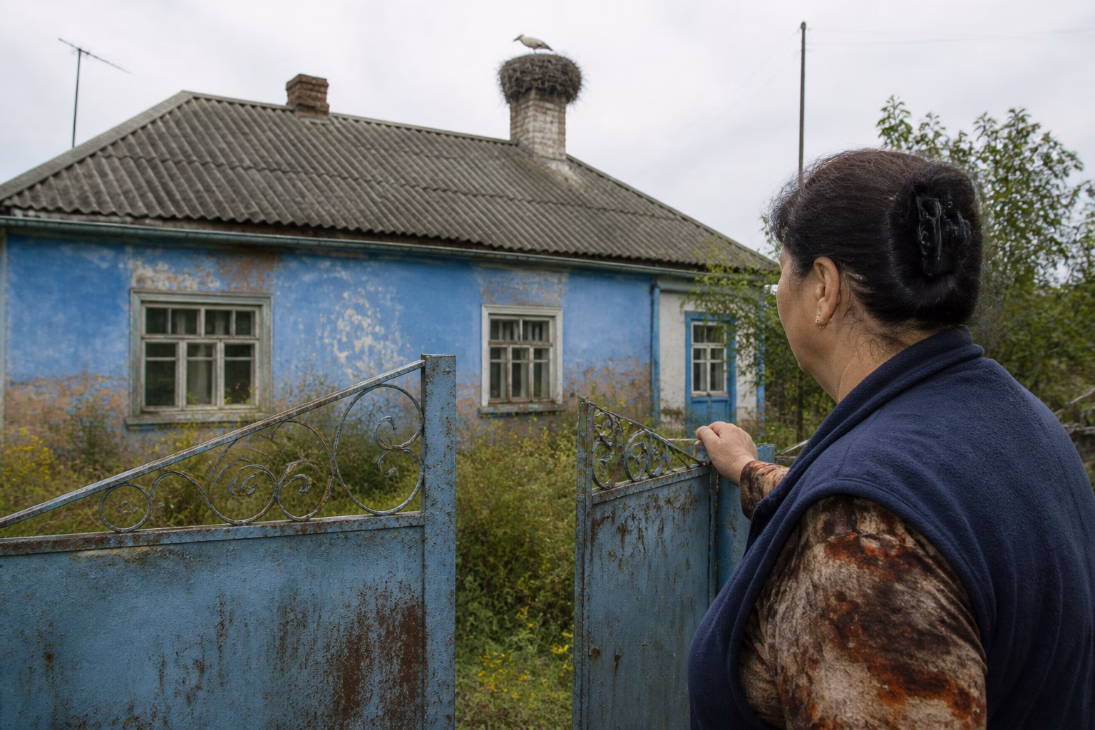 Жінка з ностальгією дивиться на старе подвір'я дитинства