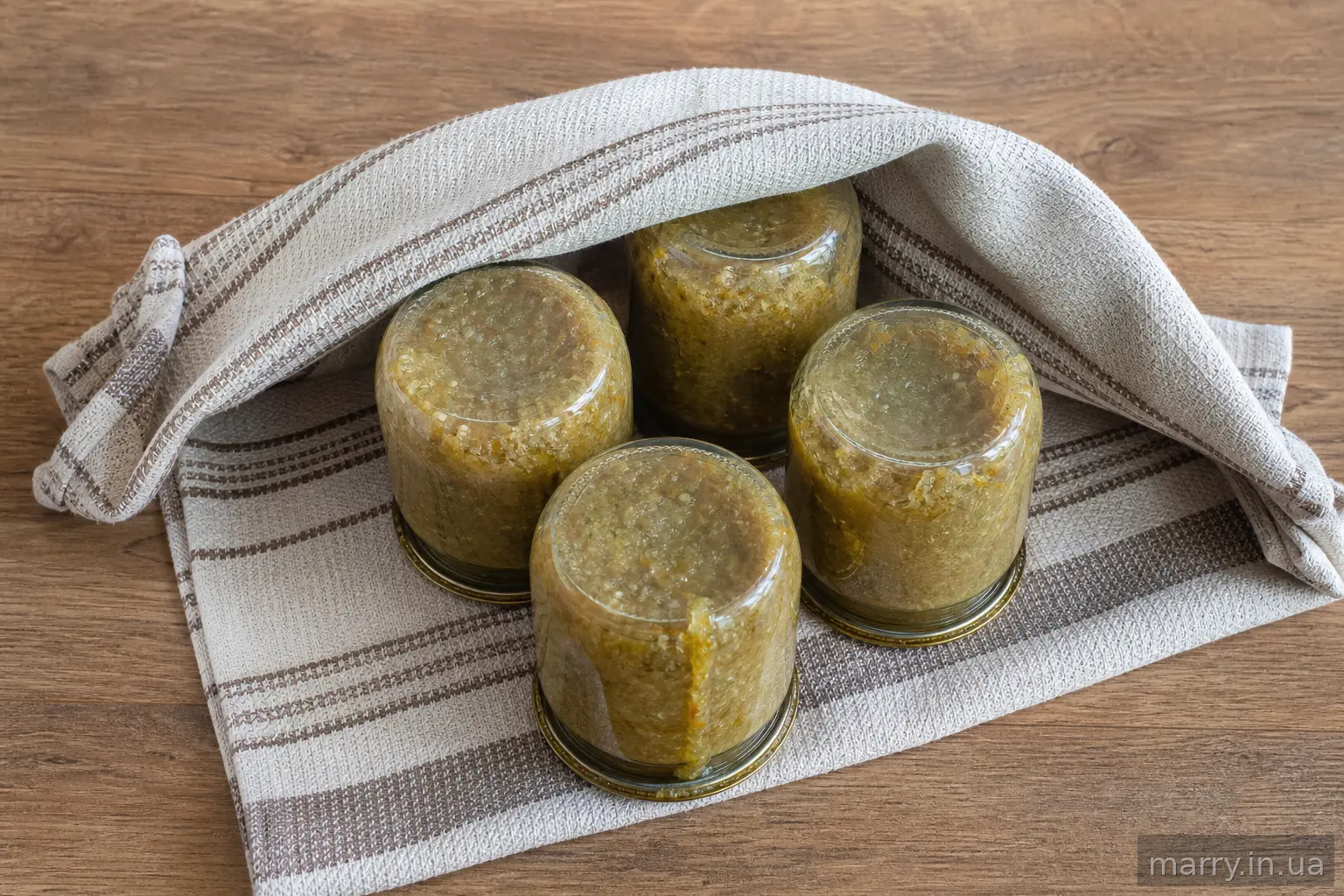 Банки з ікрою перевернуті догори дном під рушником після стерилізації